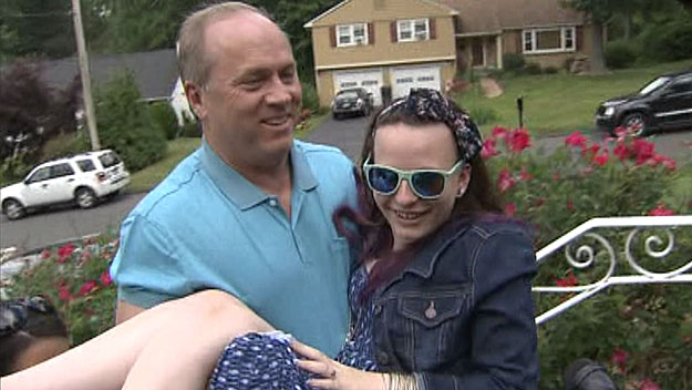 Lou Pelletier carries his daughter Justina into their Connecticut home after she was released into her parents' custody June 18, 2014. (WBZ-TV)