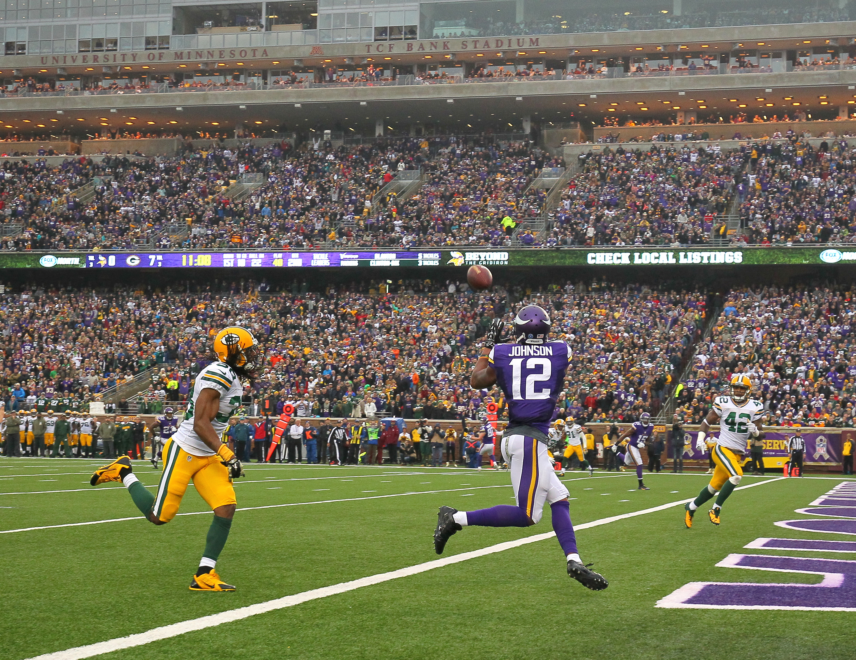 Vikings receiver Charles Johnson pulls in a touchdown while Tramon Williams of the Green Bay Packers watches. (Photo by Adam Bettcher/Getty Images)