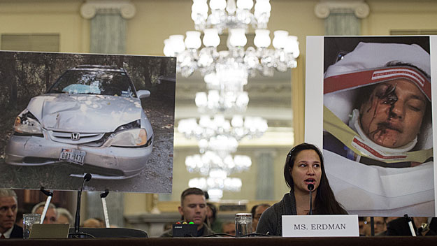 Air Force Lt. Stephanie Erdman, whose eye was injured by airbag shrapnel from her 2002 Honda Civic, is surrounded by pictures showing the accident as she testifies before the US Senate Committee on Commerce, Science, and Transportation on Capitol Hill in Washington, DC, November 20, 2014, on the Takata airbag defects and the vehicle recall process. (Photo credit JIM WATSON/AFP/Getty Images)