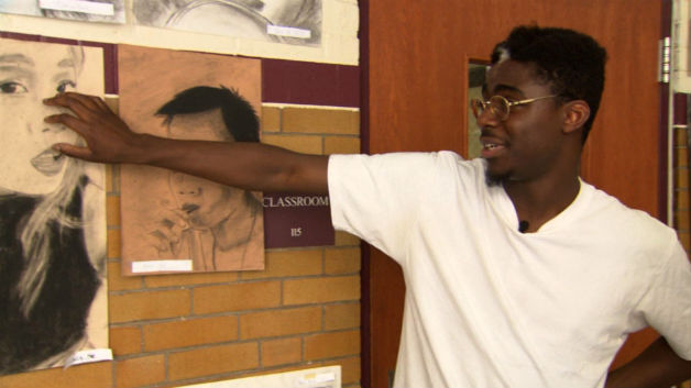 Senior Phillip Sossou shows off his artwork at Boston Latin School on Friday. (WBZ-TV)