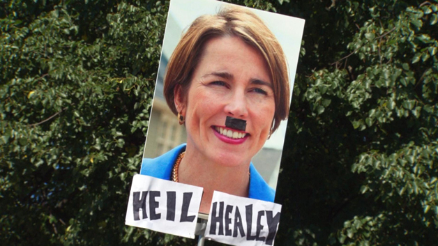 A gun advocate holds a sign in protest of AG Maura Healey. (WBZ-TV)