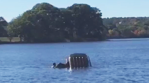 Bystanders rush to help a woman out of her sinking car. (Image Credit: Arlington Police Department)