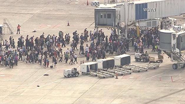 People fled to safety on the tarmac after a shooter killed multiple people inside the Fort Lauderdale airport Friday. (WBZ-TV)